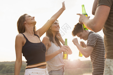 一群朋友在海滩派对喝酒说笑图片