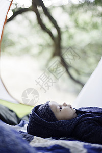 婴儿男孩躺在毛毯上帐篷里图片
