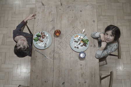 姐和哥在厨房餐桌边吃饭的光头肖像图片