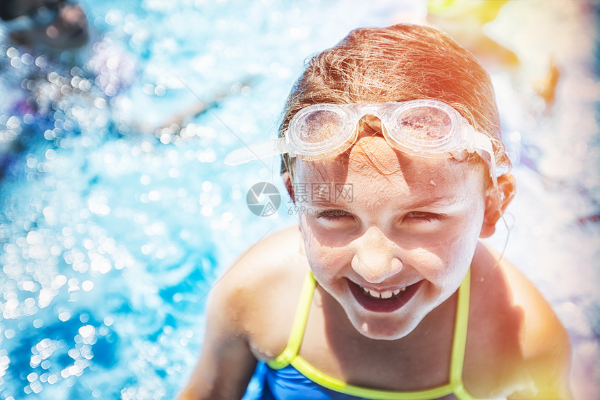 阳光下游泳池里的女孩在微笑图片