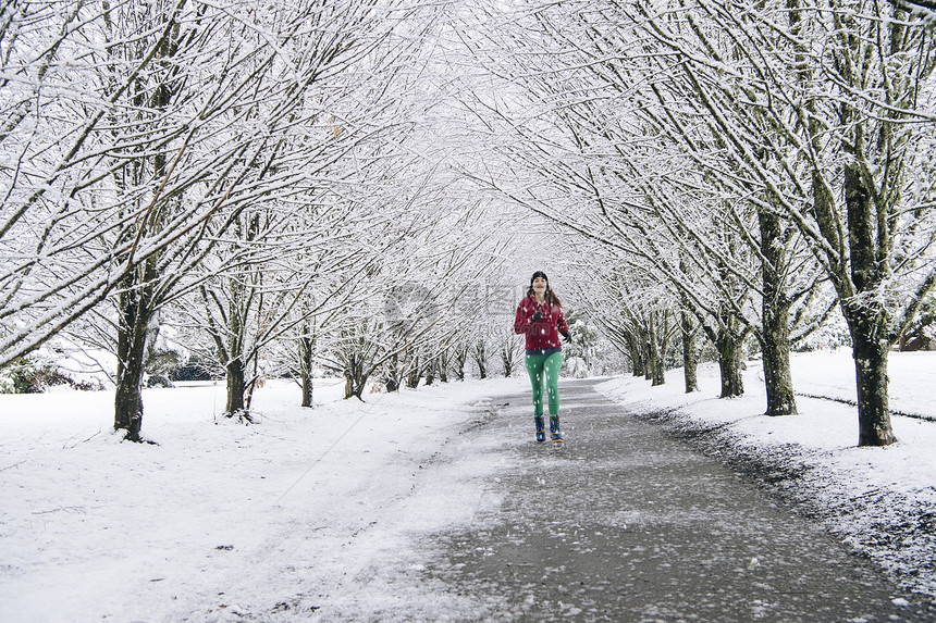 在雪中妇女沿路跑步图片