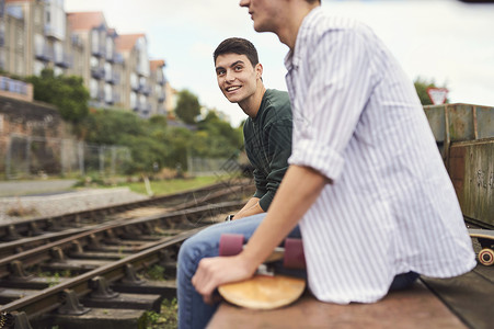 2名青年男子坐在火车轨道旁英国布里斯托尔图片