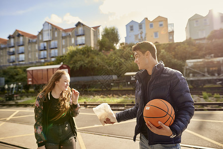 年轻人与朋友分享一袋薯片年轻人拿着篮球英国布里斯托尔图片