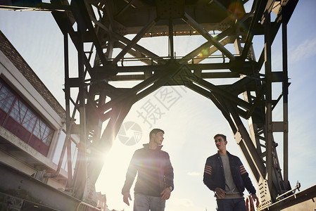2名青年男子在桥下行走图片