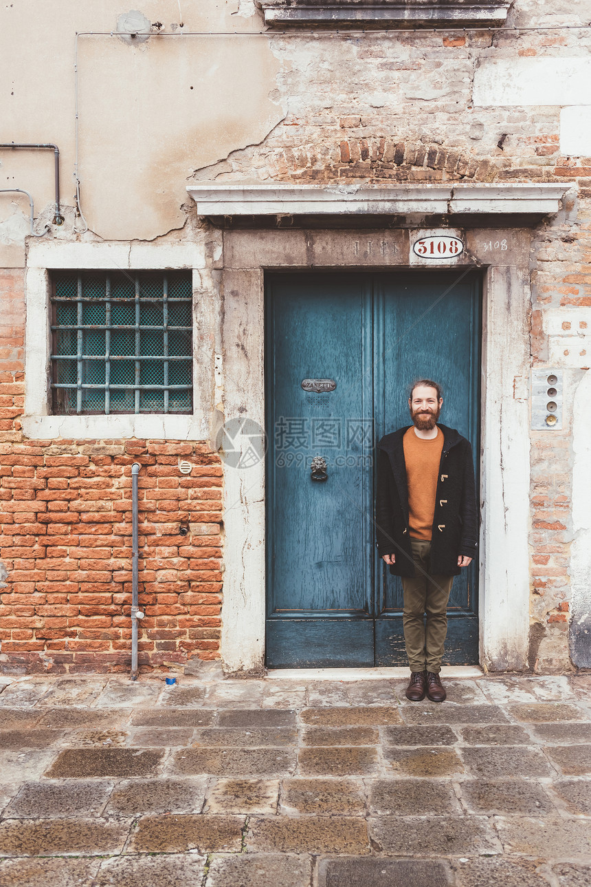 站在意大利威尼斯旧门前的长胡子中年男肖像图片