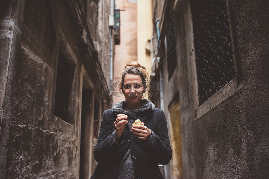 黑暗小巷里年轻女人吃冰淇淋图片