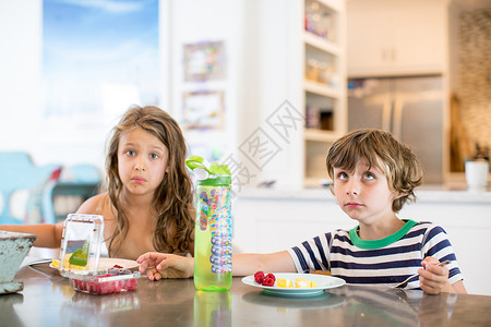 厨房桌边的男孩和女孩图片