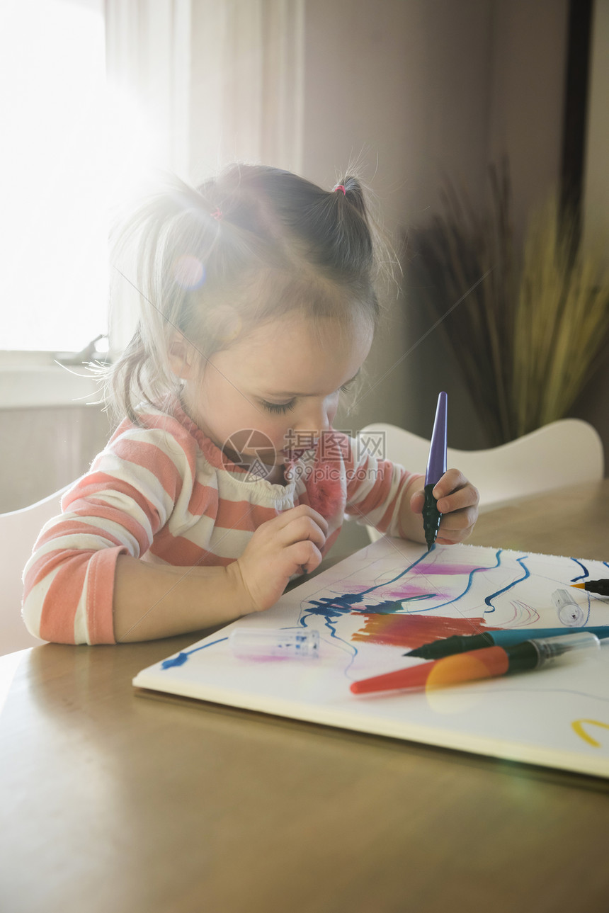 女幼儿在桌边绘画草图本中的女幼儿图片