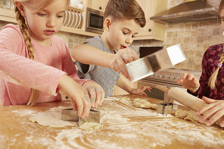 女孩和男在厨房餐桌上烤明星粉状糕饼高清图片