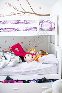 穿着软玩具睡在床上的女孩肖像图片