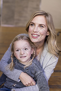 母亲和女儿的肖像坐在地板上微笑图片