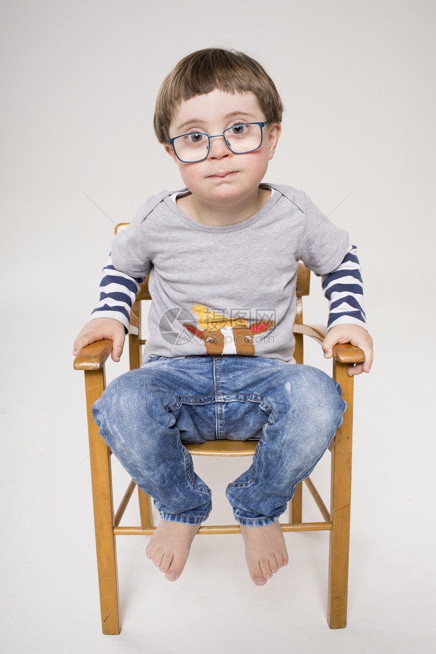 坐在木椅子上的小男孩肖像图片