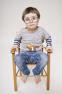 坐在木椅子上的小男孩肖像图片