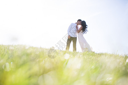 浪漫情侣在草地山上接吻图片