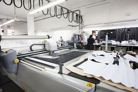 真人设计素材在服装厂切割纺织品的模式切割机背景