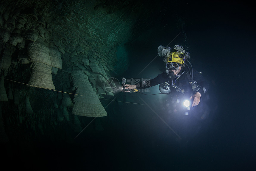Scuba潜水员探索丛林下沉洞穴中被称为铃声的独特自然构造图片