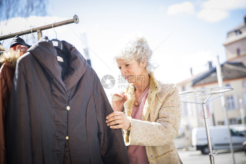 在当地市场看服装的女顾客图片