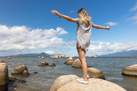 少女在海边岩石上图片