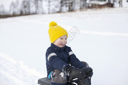 小孩在雪地玩雪橇图片
