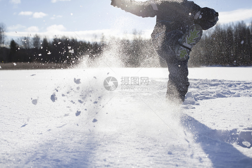 小男孩在雪中玩耍图片