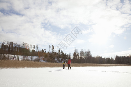 父亲和孩子在雪地里行走图片