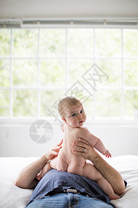 坐在父亲身上的婴儿背景图片