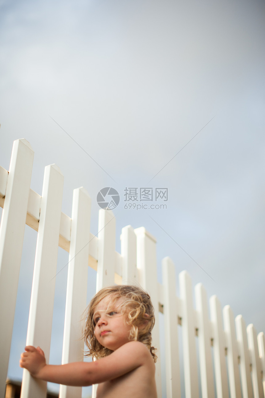 小男孩扶着白色栏杆图片
