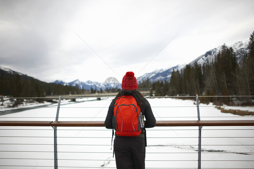 加拿大班夫一位徒步旅行者在桥上看雪山图片