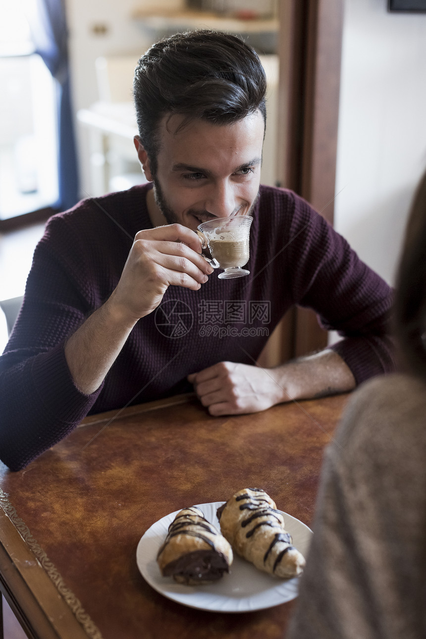 坐在桌边喝咖啡的男人图片