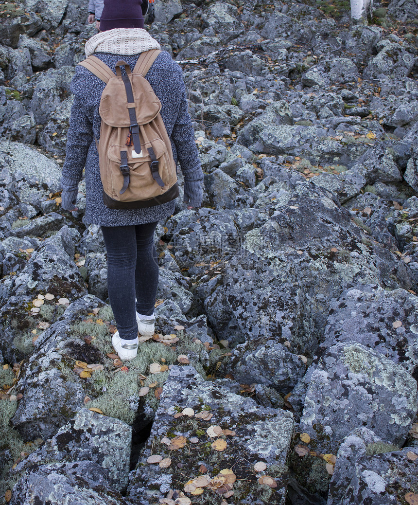 在俄罗斯维尔德洛夫克州的岩石地上远足的年轻女子图片