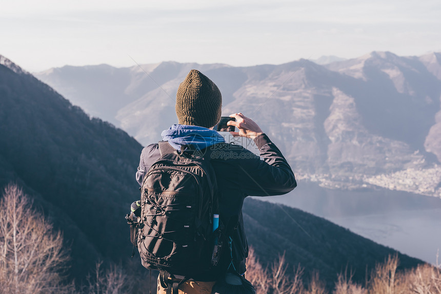 意大利圣普里莫山男徒步旅行者拍摄湖光山色的背影图片