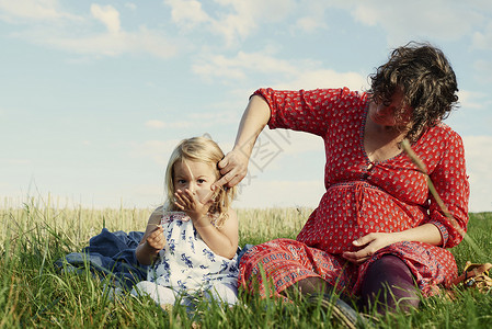 海布希特孕妇与女儿一起在田野中玩耍背景