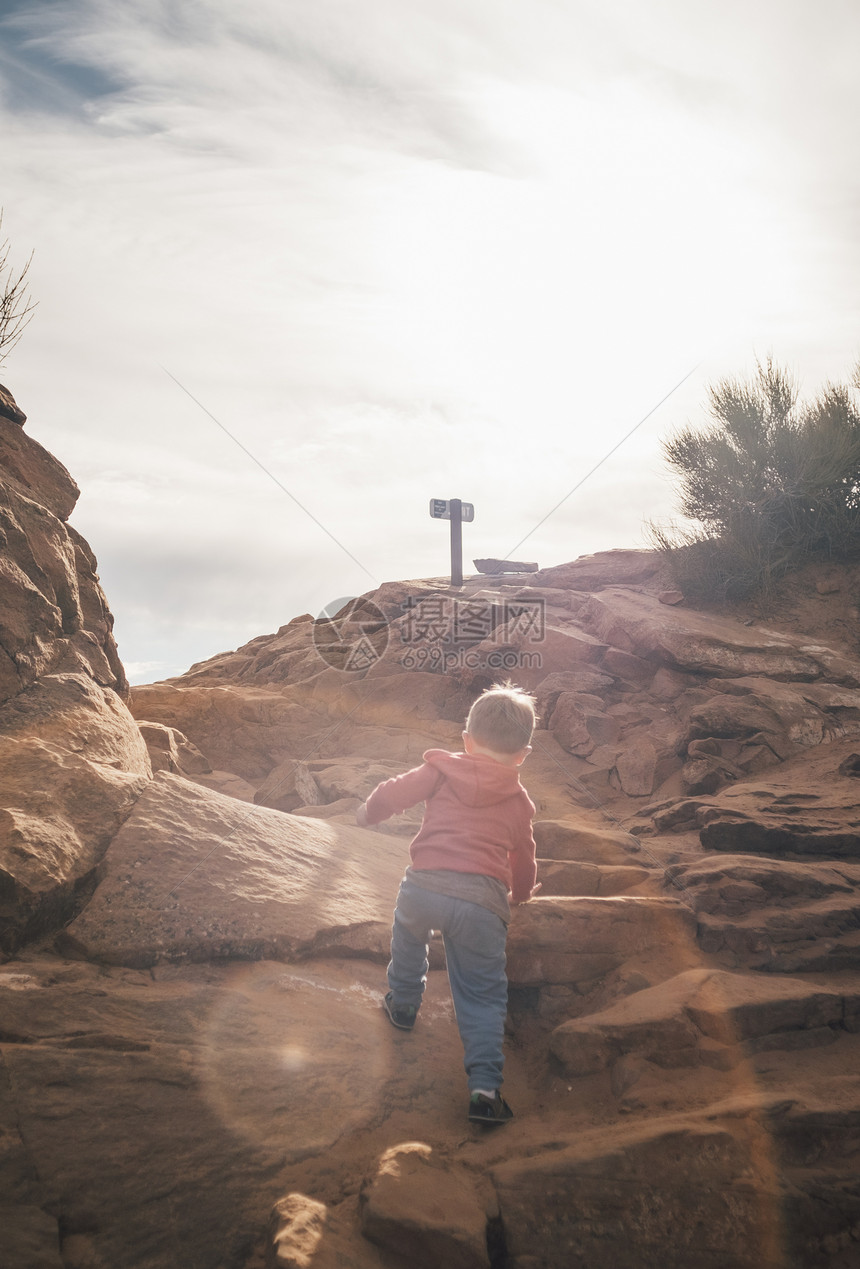 美国犹他州摩押沙漠中的小男孩攀岩图片