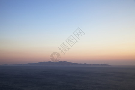 希腊日落时从蒂诺斯岛到安德罗的海景和远视图片