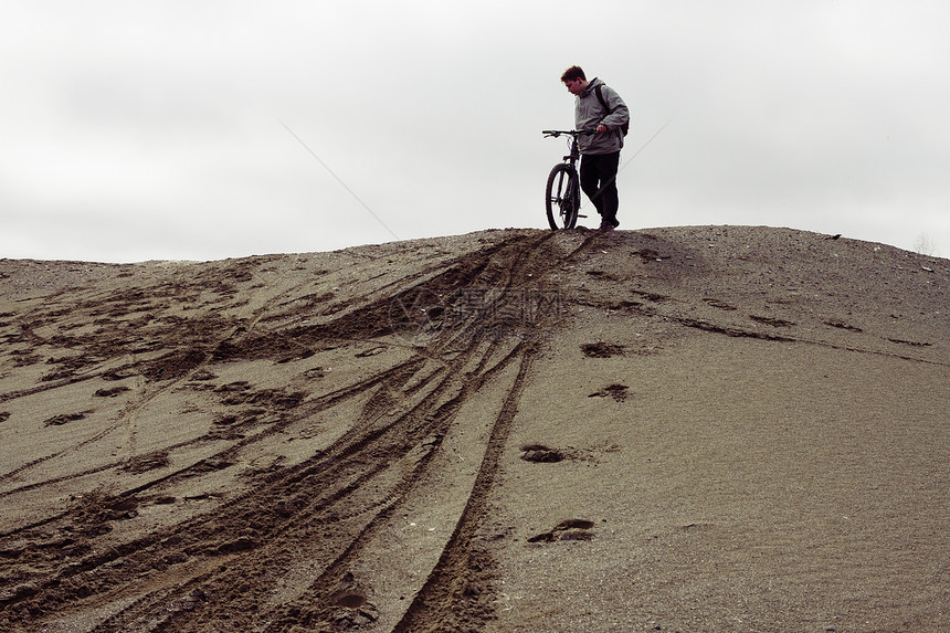 年轻的男山骑自行车者准备从采石山骑自行车下来图片