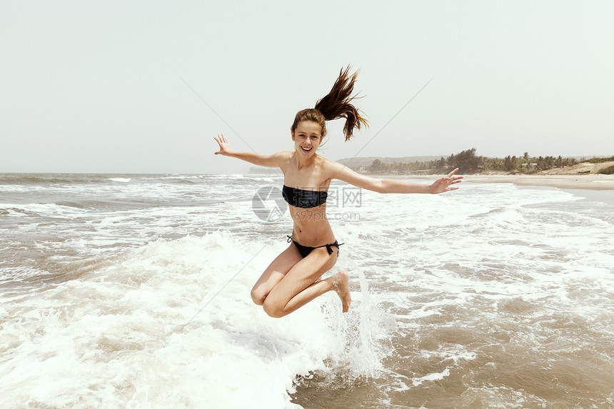 十几岁的女孩在海里跳跃图片