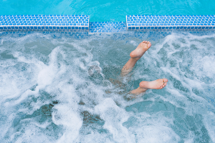 潜水男孩的脚在露天游泳池中图片