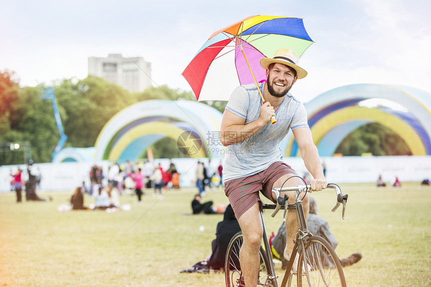 撑着雨伞骑自行车的男子图片