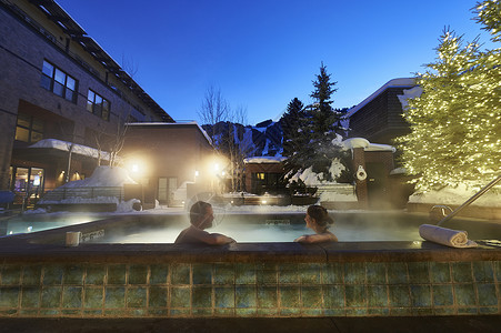 人热水浴缸在美国科罗拉多州阿斯彭黄昏户外泡温泉背景