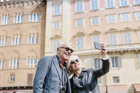 意大利托斯卡纳锡耶市Sieena旅游夫妇使用智能手机自拍图片