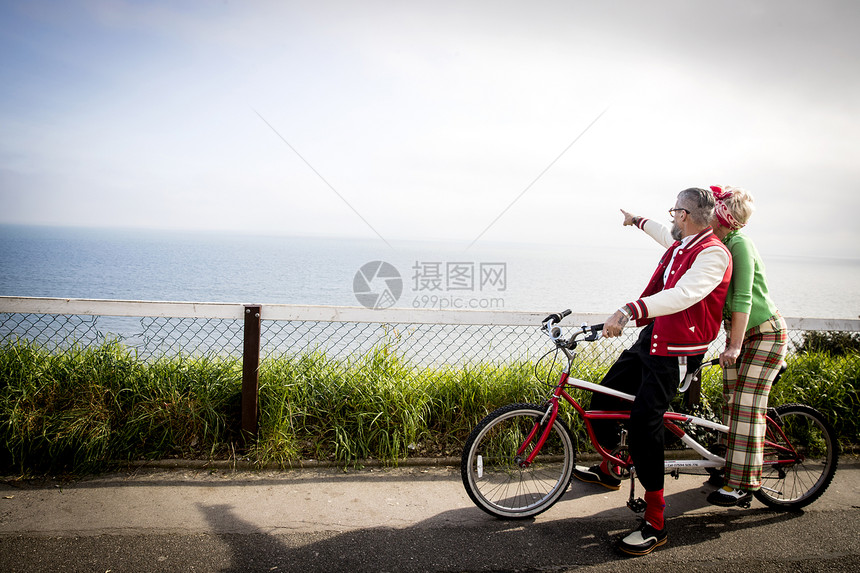 英国伯恩茅斯乘坐双人自行车观光的情侣图片
