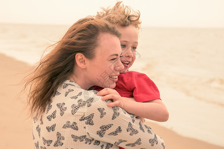在海滩上抱着儿子的母亲图片