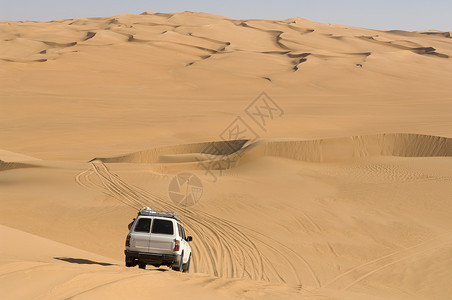 撒哈拉沙漠利比亚费赞沙漠上行驶的越野车背景图片