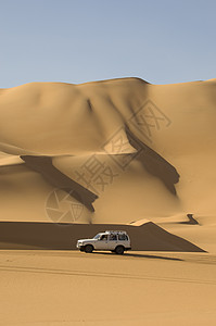 撒哈拉沙漠上行驶的越野车背景图片