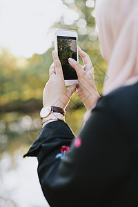 年轻女子用智能手机照相图片