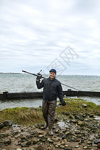 年轻男肩上靠着钓鱼杆背景图片