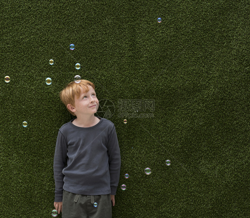 男孩站在泡泡中微笑图片