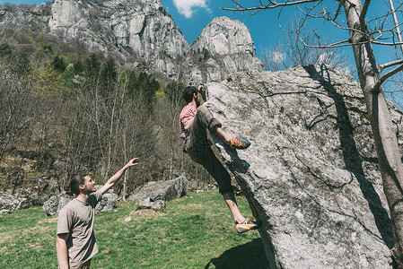 意大利隆巴迪Lombardy年轻男巨人指向女攀岩巨人图片
