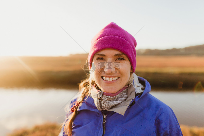 美国加利福尼亚MorroBay日落时美国加利福尼亚州MorroBay河岸上戴粉红色帽子的妇女肖像图片