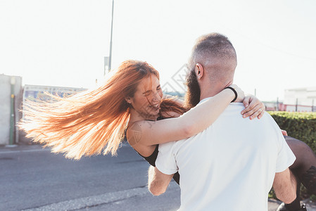 男人怀着的女人在微笑图片